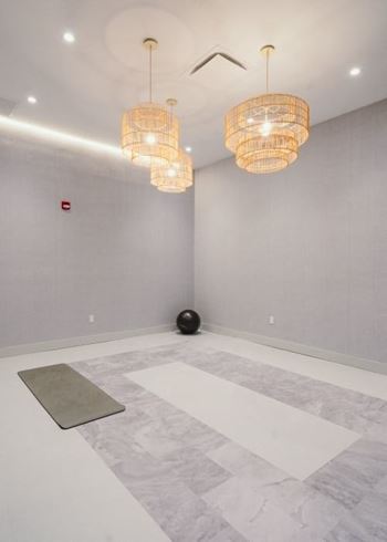 an empty room with two chandeliers and a rug